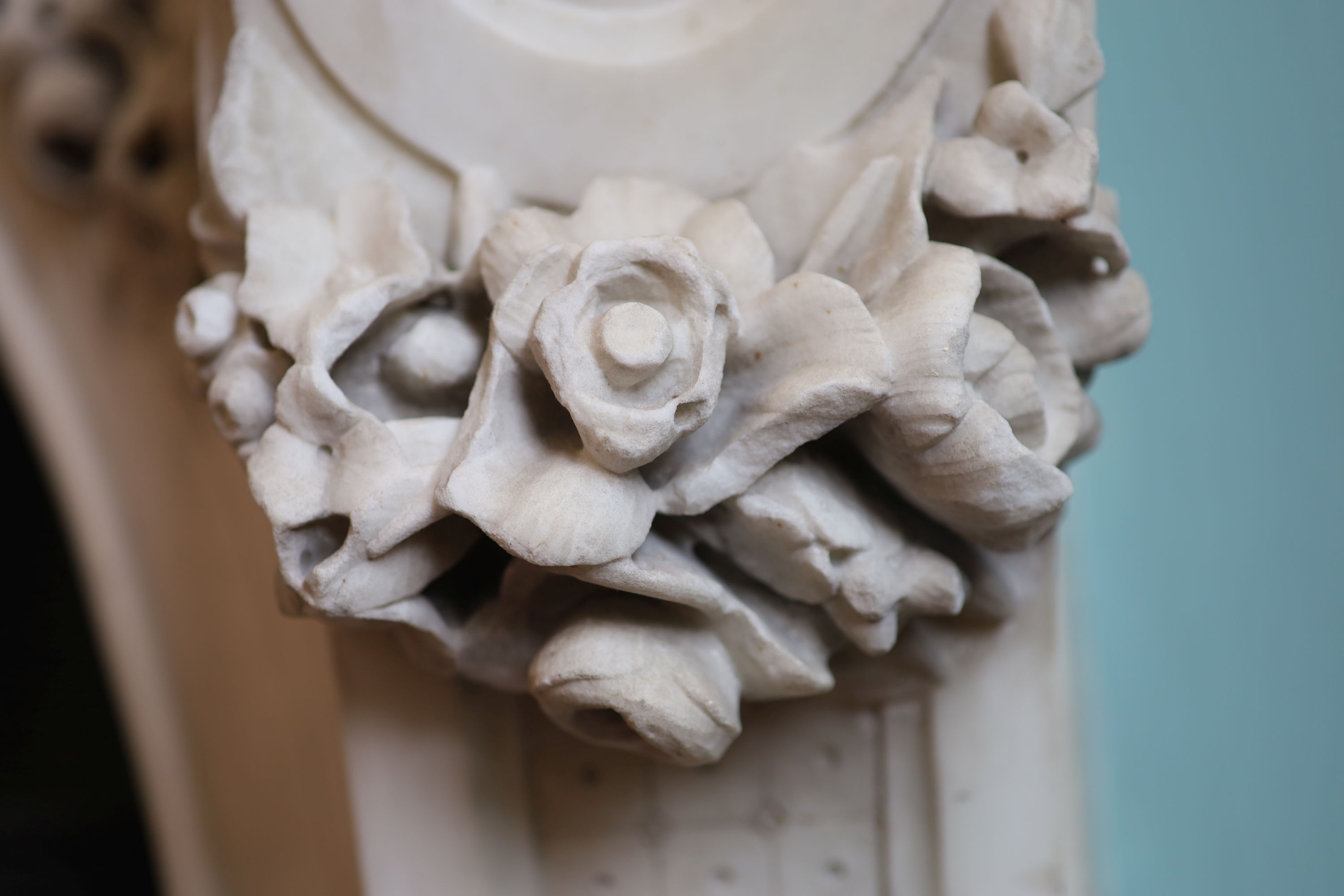 An important mid 19th century Italian white Carrara marble chimney piece, carved in the rococo taste, with seated putti, foliage swags